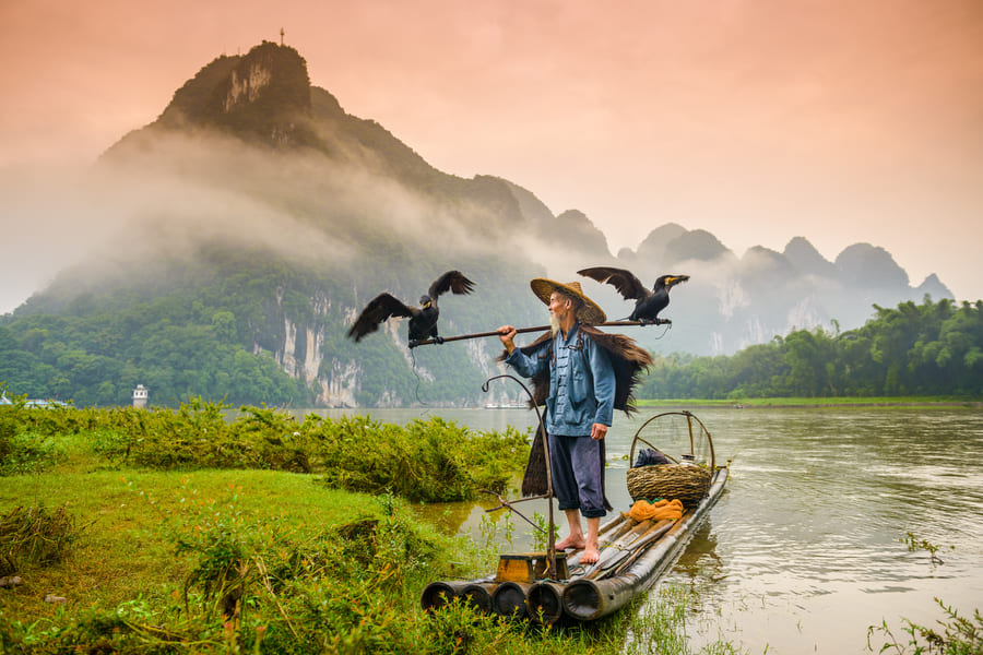 Hombre local sobre una balsa en un rio de Yangshuo. China.